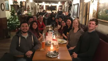A group of people seated at a dining table in a festive restaurant with Christmas decorations.